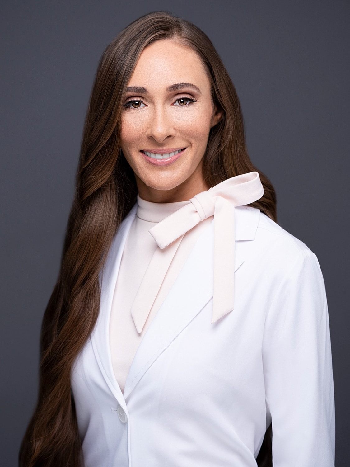 Female professional in white coat smiling warmly