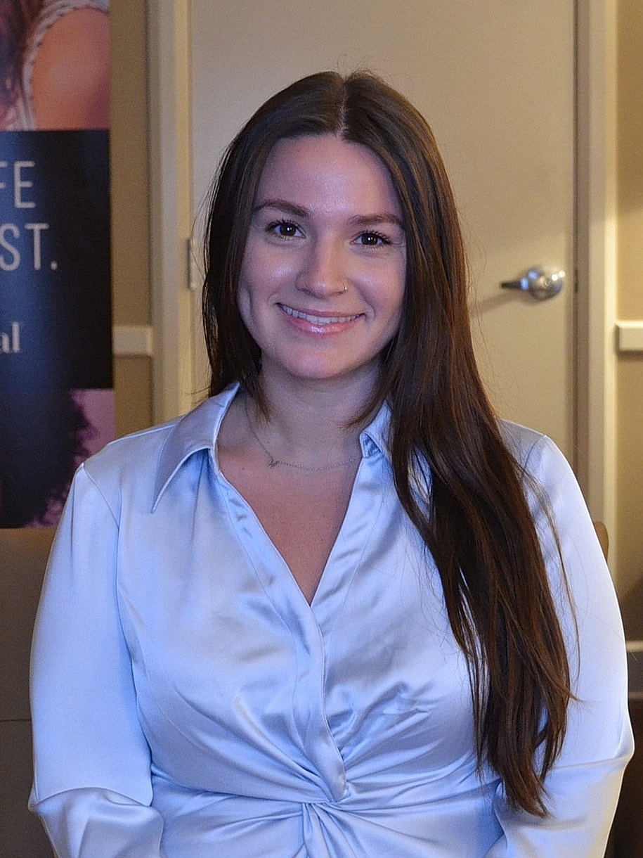 Smiling woman in a light blue blouse.