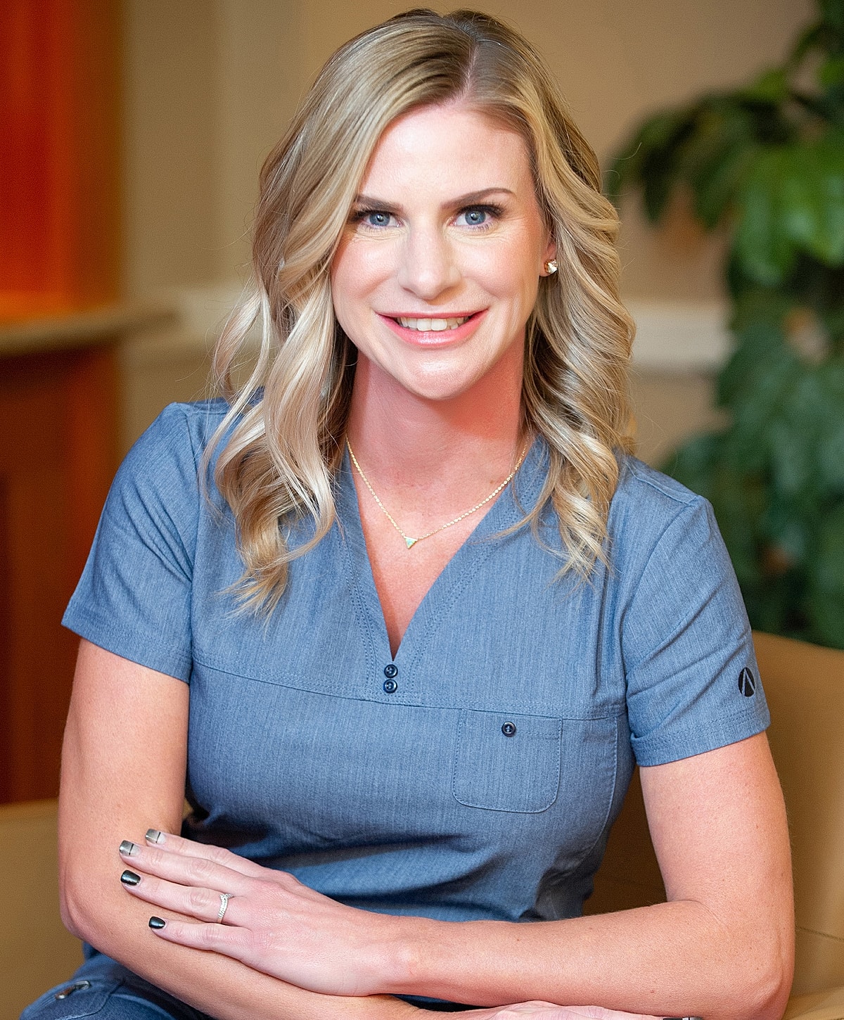 Smiling woman in professional attire, relaxed setting.