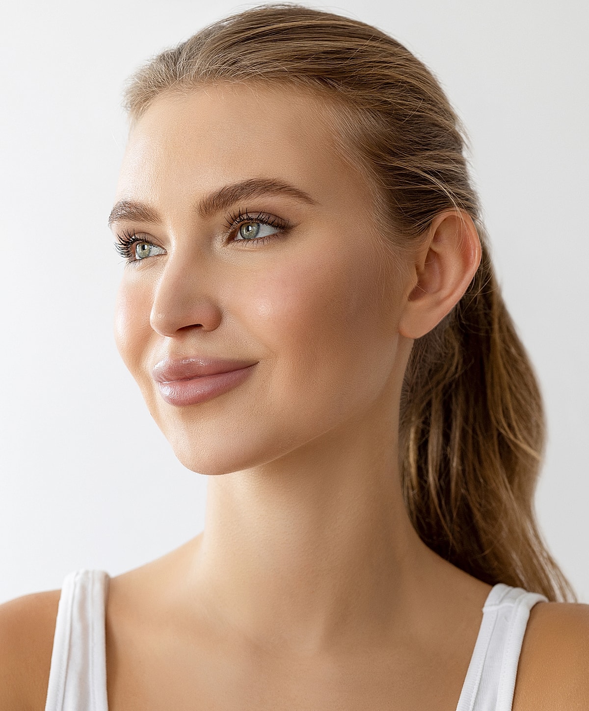 Applying facial treatment to a relaxed client.