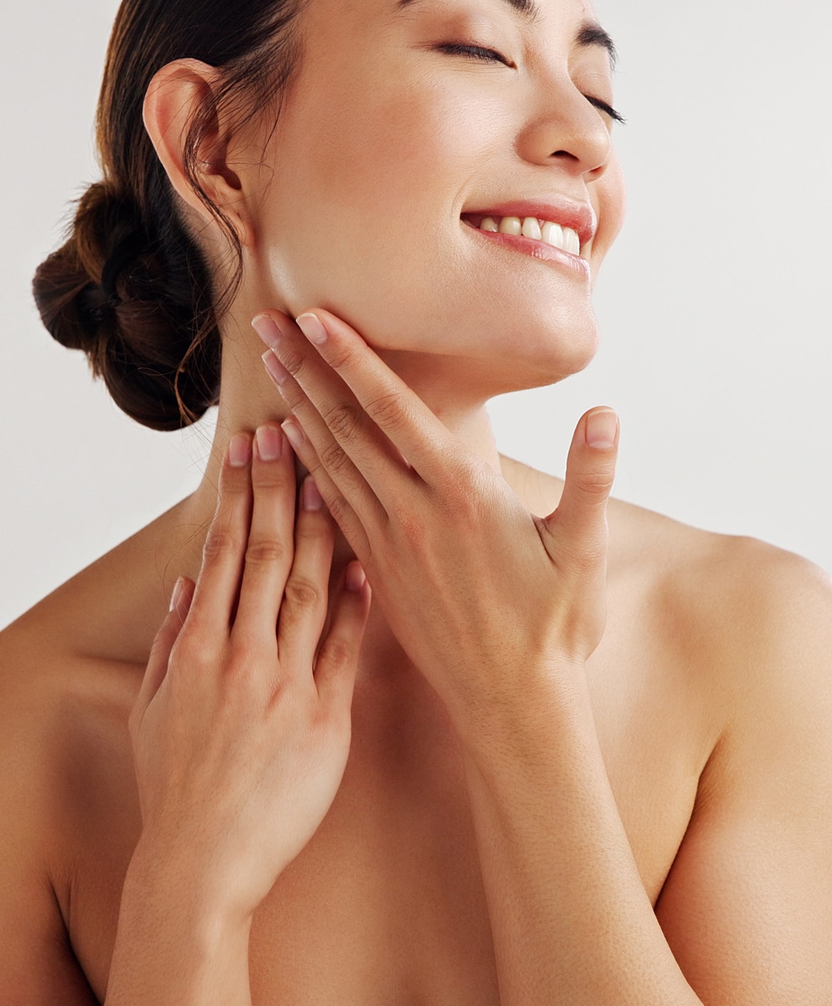 Woman applying skincare in bathroom setting.