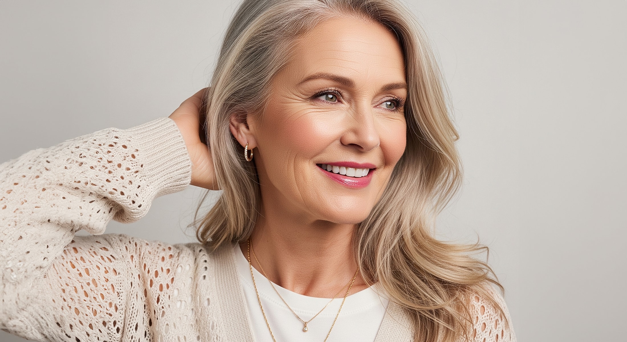 Smiling woman with long, light gray hair.