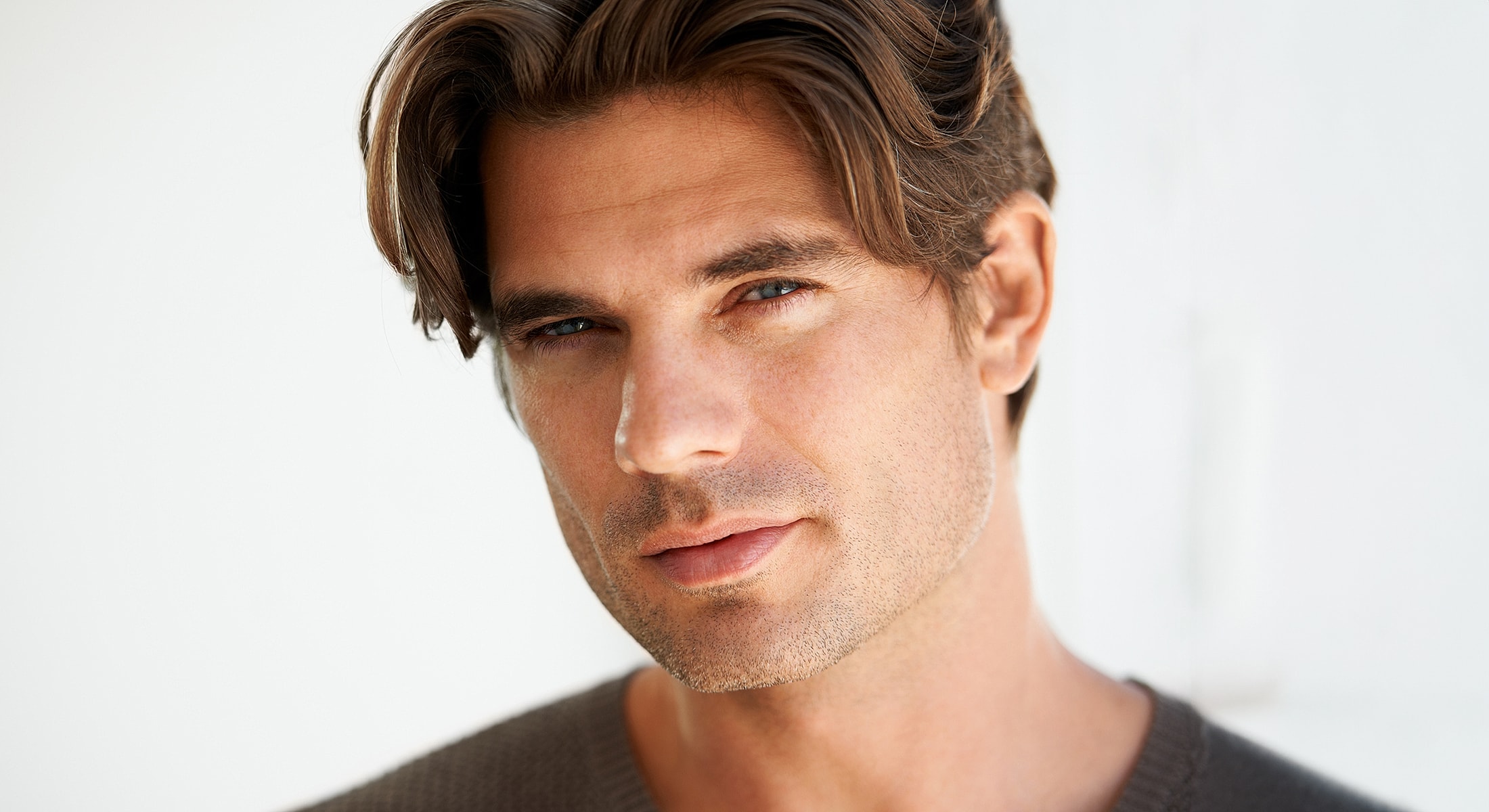 Close-up portrait of man with wavy hair.
